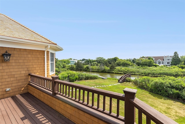 deck with a yard and a water view