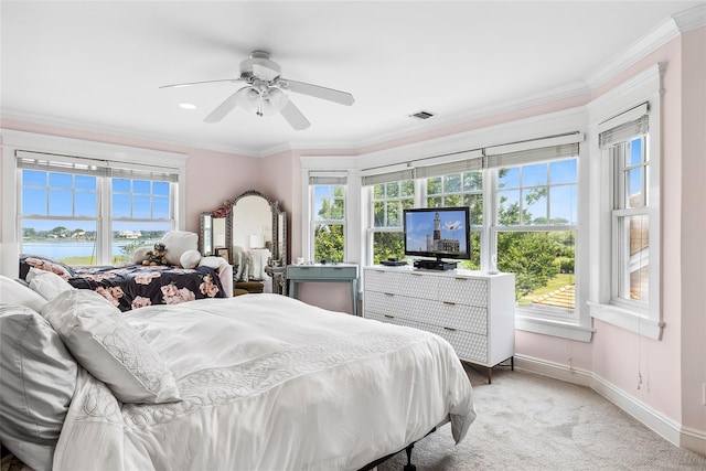 carpeted bedroom featuring ceiling fan, ornamental molding, and multiple windows