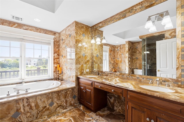 bathroom with vanity, tiled bath, toilet, and tile walls