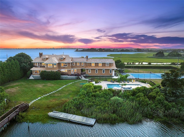 aerial view at dusk featuring a water view