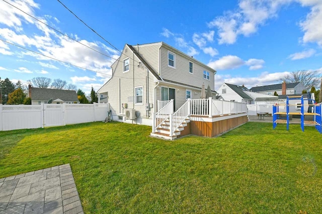 rear view of house featuring ac unit, a deck, and a lawn