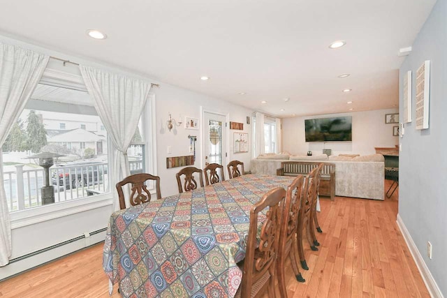 dining area with light hardwood / wood-style floors and baseboard heating