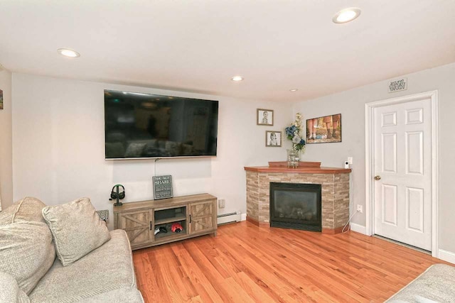 living room with wood-type flooring and baseboard heating