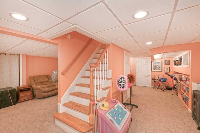 basement featuring carpet flooring and a paneled ceiling