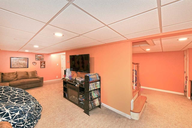 carpeted living room featuring a drop ceiling