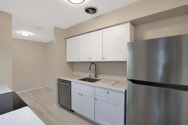 kitchen with light hardwood / wood-style flooring, white cabinets, stainless steel appliances, and sink