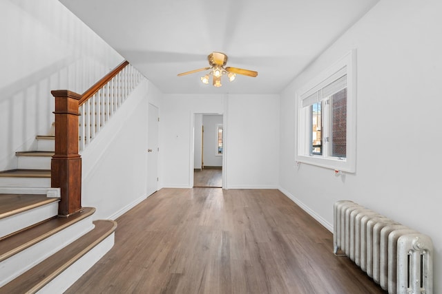 spare room featuring radiator, wood-type flooring, and ceiling fan