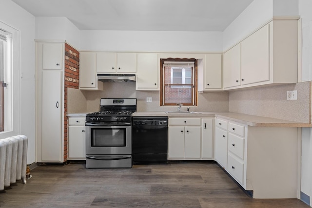 kitchen featuring sink, white cabinetry, stainless steel range with gas cooktop, radiator heating unit, and black dishwasher