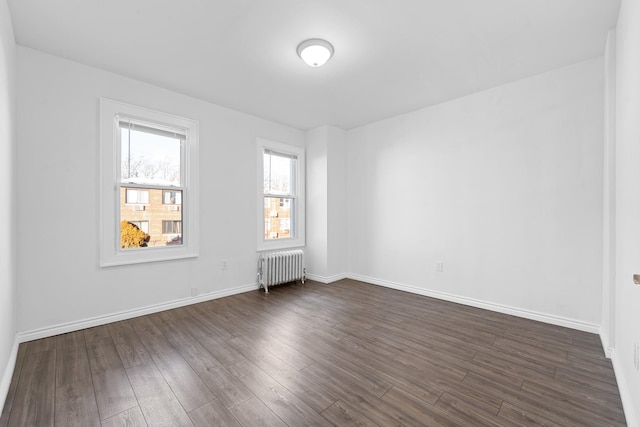 unfurnished room with dark hardwood / wood-style flooring and radiator