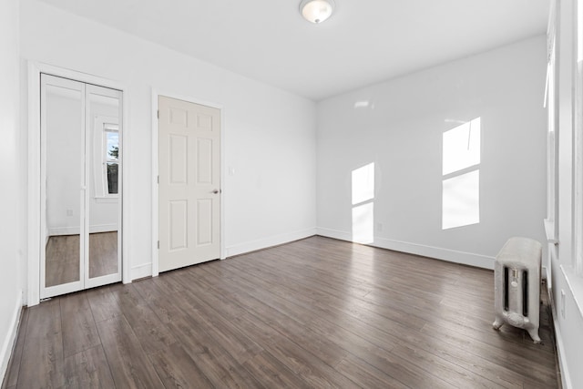 unfurnished room featuring dark wood-type flooring