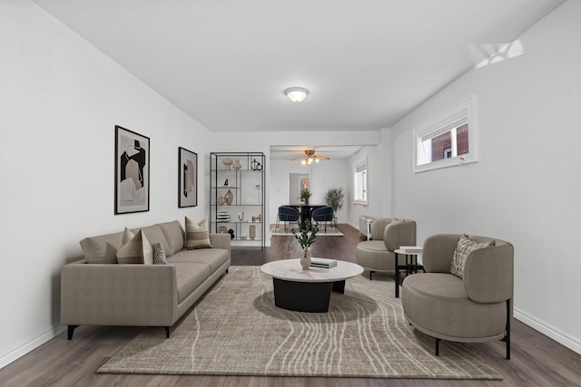 living room featuring ceiling fan and dark hardwood / wood-style flooring