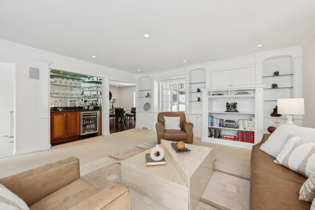 living room with ornamental molding, recessed lighting, beverage cooler, and a bar