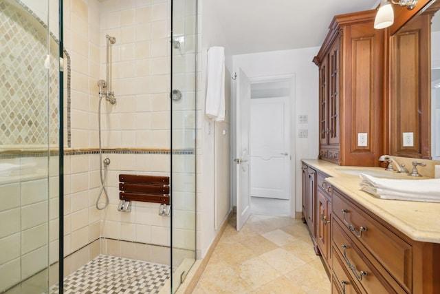 full bathroom with a stall shower, baseboards, and vanity