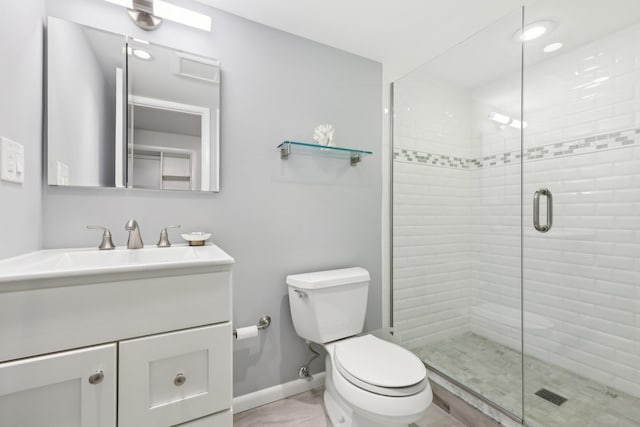 full bathroom featuring toilet, a shower stall, baseboards, and vanity