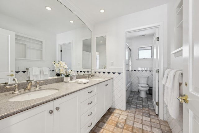 bathroom with double vanity, a sink, tile walls, and recessed lighting