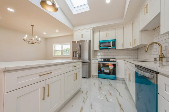 kitchen with appliances with stainless steel finishes, backsplash, light stone counters, sink, and decorative light fixtures