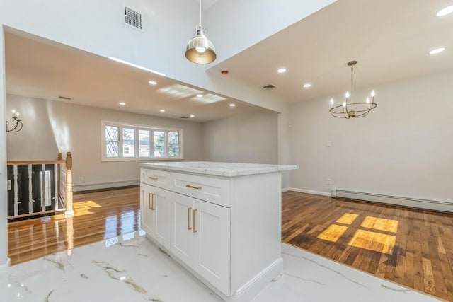 kitchen featuring white cabinets, pendant lighting, and a baseboard heating unit