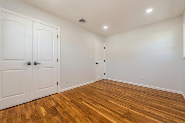 unfurnished bedroom with wood-type flooring and a closet