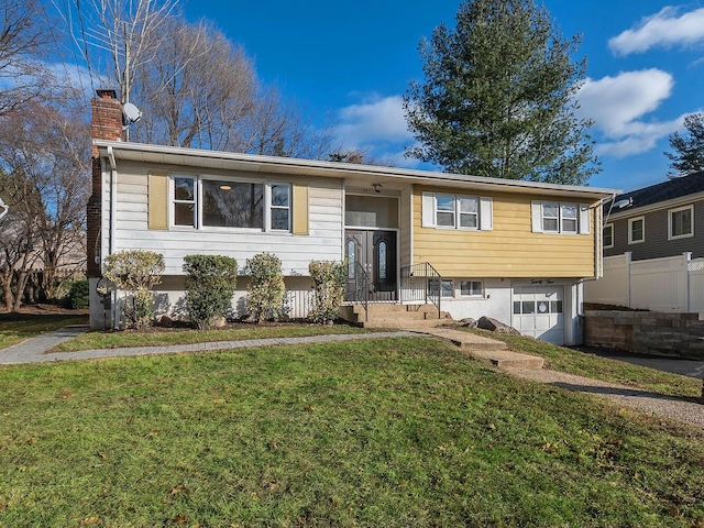 raised ranch with a front yard and a garage