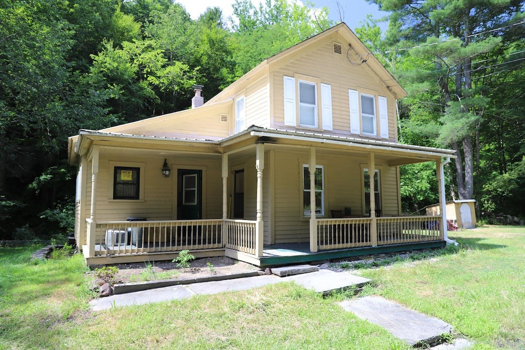 view of front of home with covered porch and a front yard