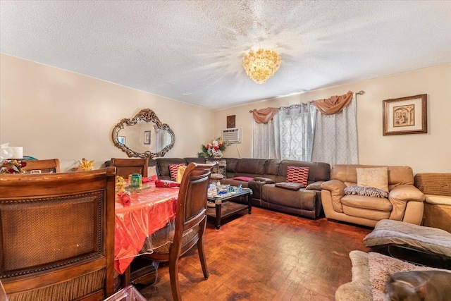 living room with dark parquet floors, a wall mounted air conditioner, and a textured ceiling