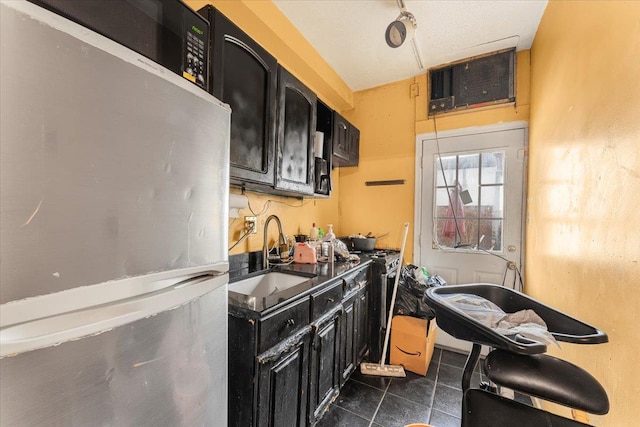 kitchen featuring stainless steel fridge, dark tile patterned floors, and sink