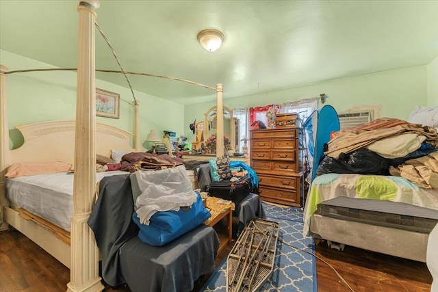 bedroom featuring a wall mounted AC and dark hardwood / wood-style flooring