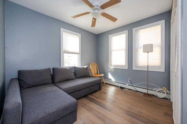 living room featuring baseboard heating, ceiling fan, and hardwood / wood-style floors