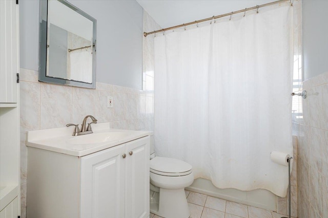 bathroom featuring tile patterned flooring, vanity, toilet, and tile walls