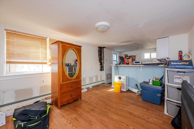 misc room with hardwood / wood-style floors, a baseboard radiator, and plenty of natural light