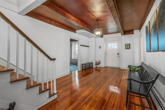 entrance foyer featuring an inviting chandelier, wood ceiling, beam ceiling, and hardwood / wood-style floors