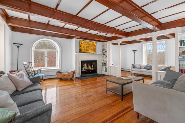 living room featuring light hardwood / wood-style floors, plenty of natural light, built in shelves, and ornate columns