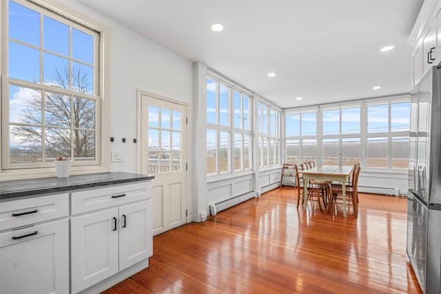 unfurnished sunroom featuring baseboard heating