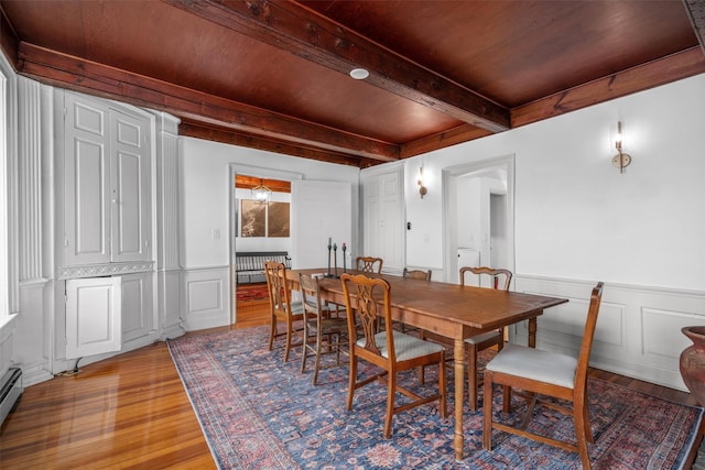 dining area with hardwood / wood-style floors, a baseboard heating unit, beam ceiling, and wood ceiling