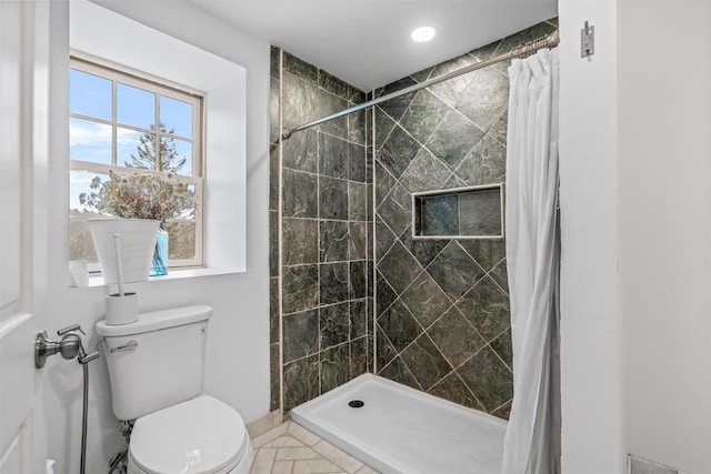 bathroom featuring toilet and curtained shower