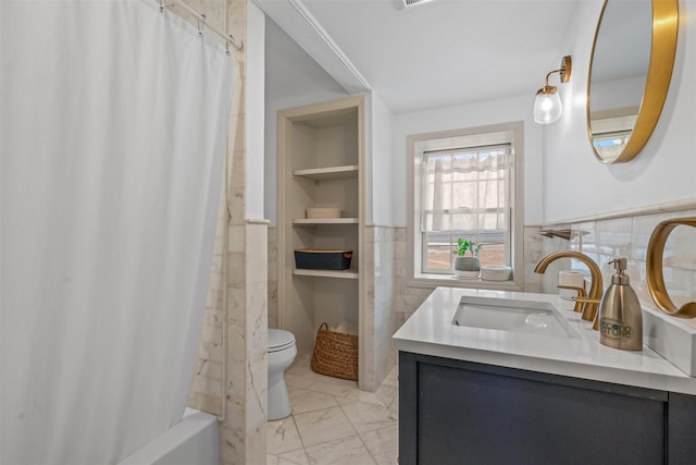 full bathroom with toilet, vanity, tile walls, shower / bathtub combination with curtain, and built in shelves