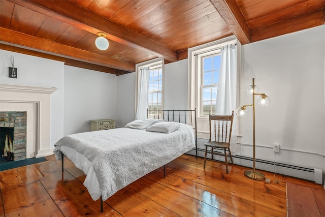 bedroom with baseboard heating, wood ceiling, a brick fireplace, and beamed ceiling