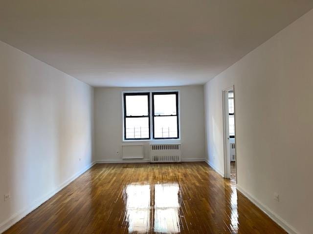 spare room with radiator and hardwood / wood-style floors