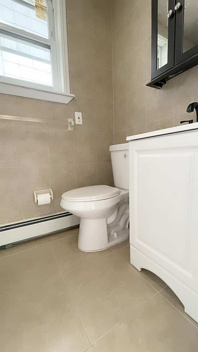 bathroom with vanity, a baseboard radiator, tile walls, tile patterned flooring, and toilet