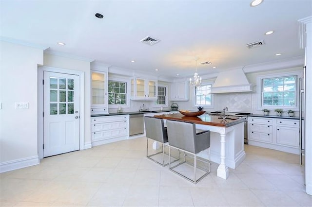 kitchen with white cabinets, custom exhaust hood, decorative backsplash, and appliances with stainless steel finishes