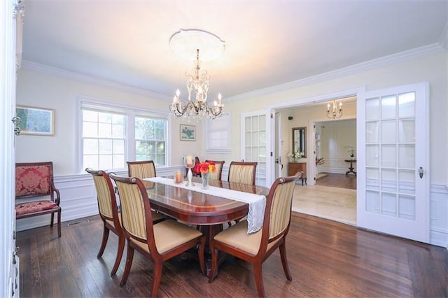 dining space with french doors, ornamental molding, dark hardwood / wood-style floors, and an inviting chandelier