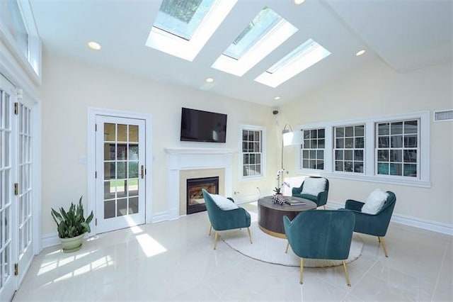 living area featuring light tile patterned floors, high vaulted ceiling, and a healthy amount of sunlight