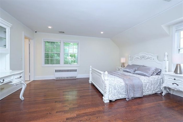 bedroom with vaulted ceiling, multiple windows, radiator heating unit, and dark hardwood / wood-style floors