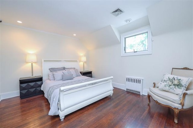 bedroom with dark hardwood / wood-style floors and radiator