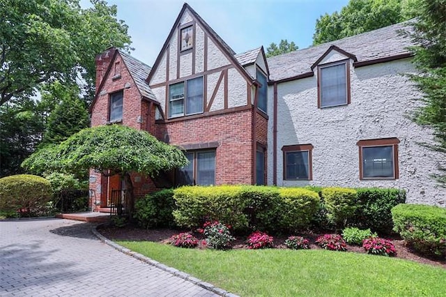 tudor house featuring a front lawn