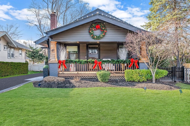 view of front facade featuring covered porch and a front yard