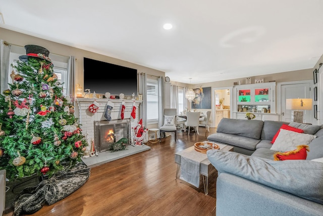 living room with hardwood / wood-style floors and a brick fireplace