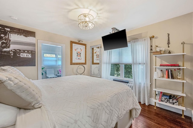 bedroom featuring dark wood-type flooring and a notable chandelier