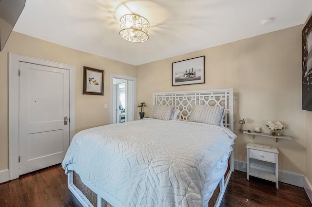 bedroom featuring dark hardwood / wood-style floors and an inviting chandelier