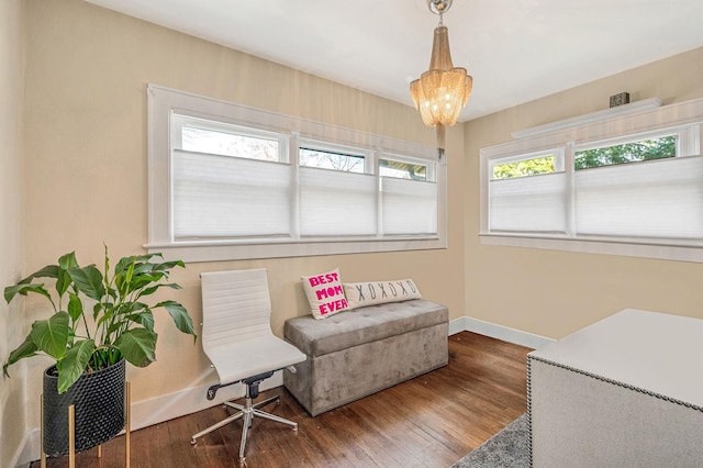 sitting room featuring wood-type flooring, a wealth of natural light, and a chandelier